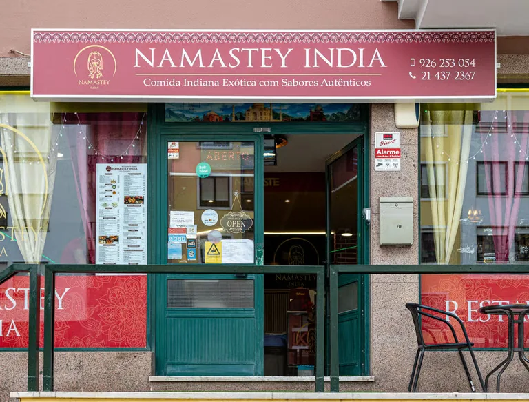 Sala do Namastey India em Massamá, com mesas postas e quadros indianos