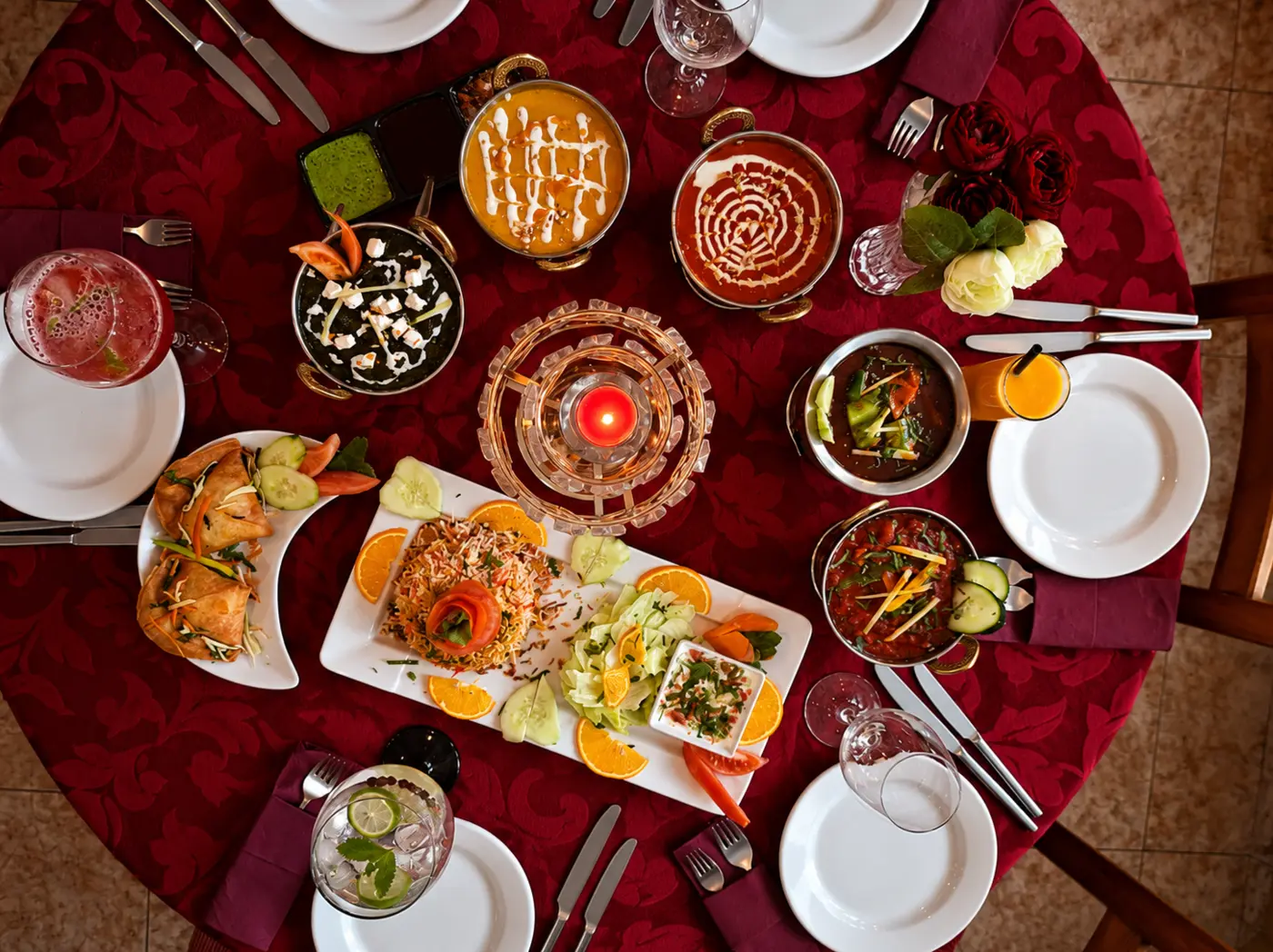 Mesa real do Namastey India com vários pratos indianos servidos em Massamá